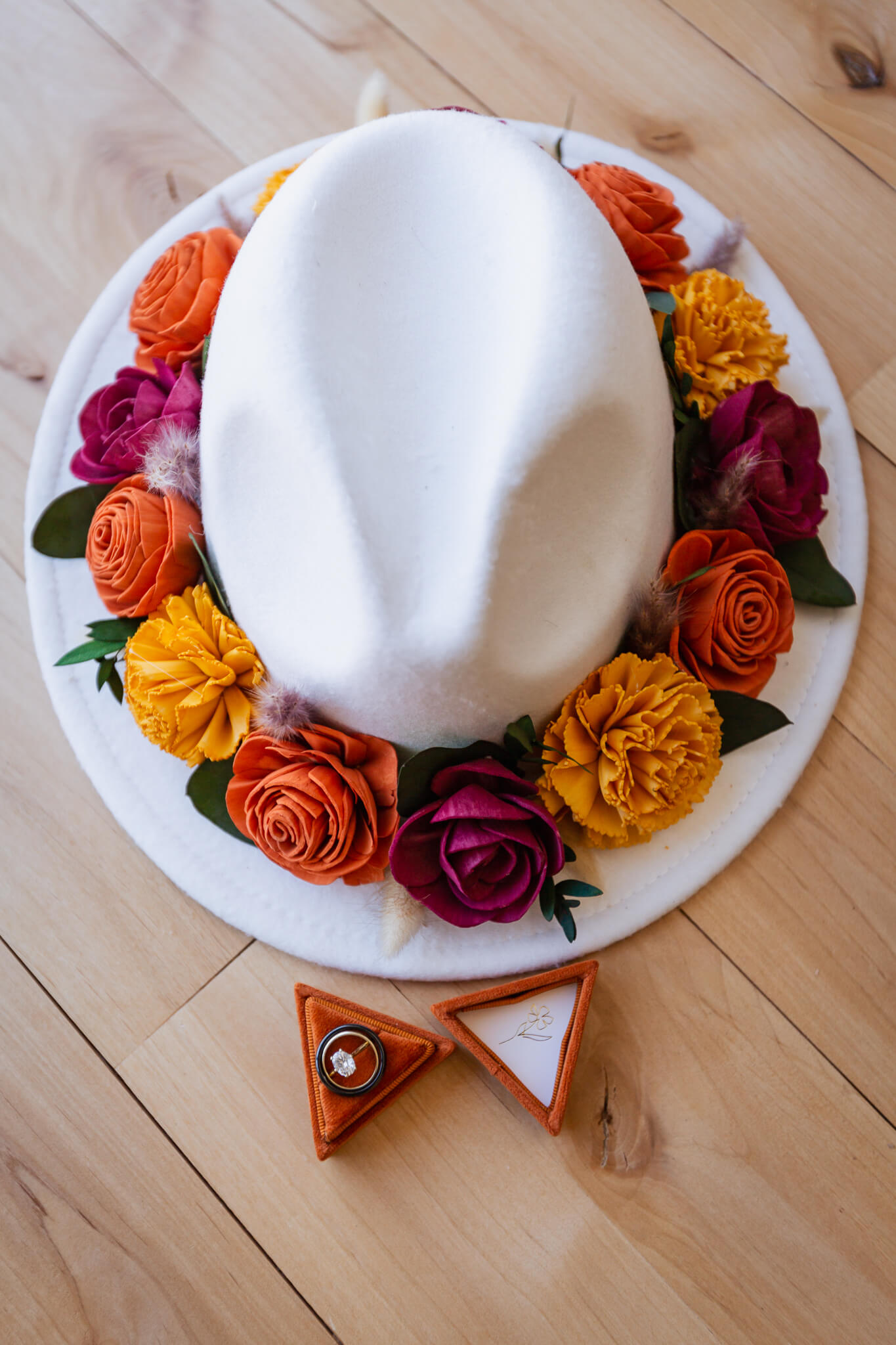Wedding details: Bride's hat next to couple's rings