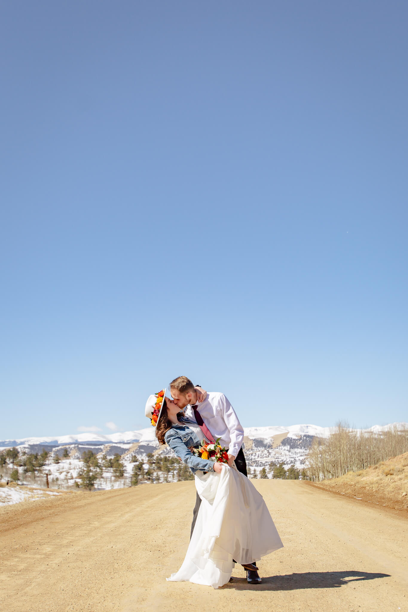 Couple kissing with the mountains in the background.