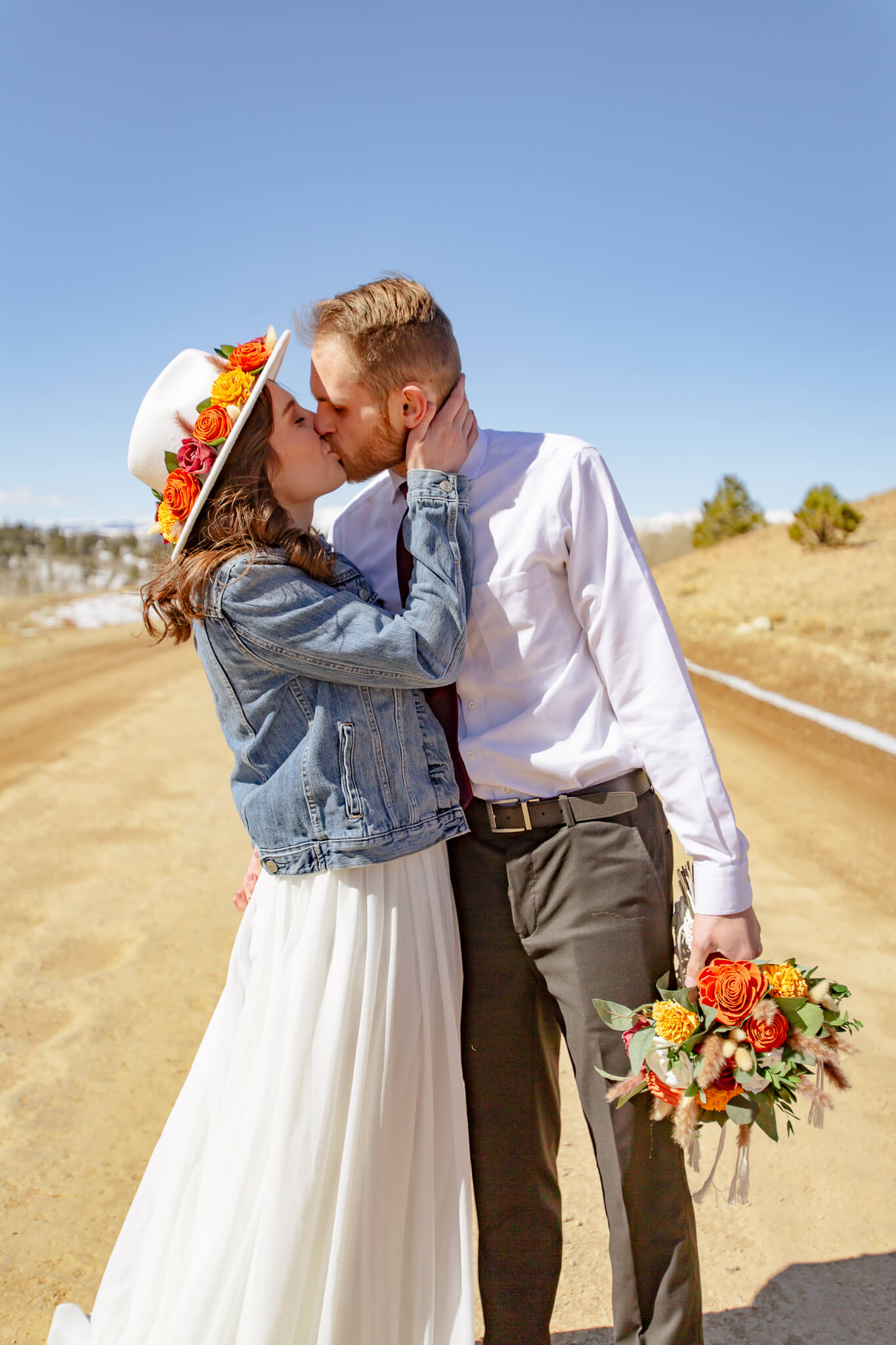 Couple kissing on a dirt road.