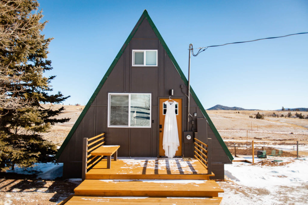 Image of tiny A-frame cabin featuring the bride's dress.