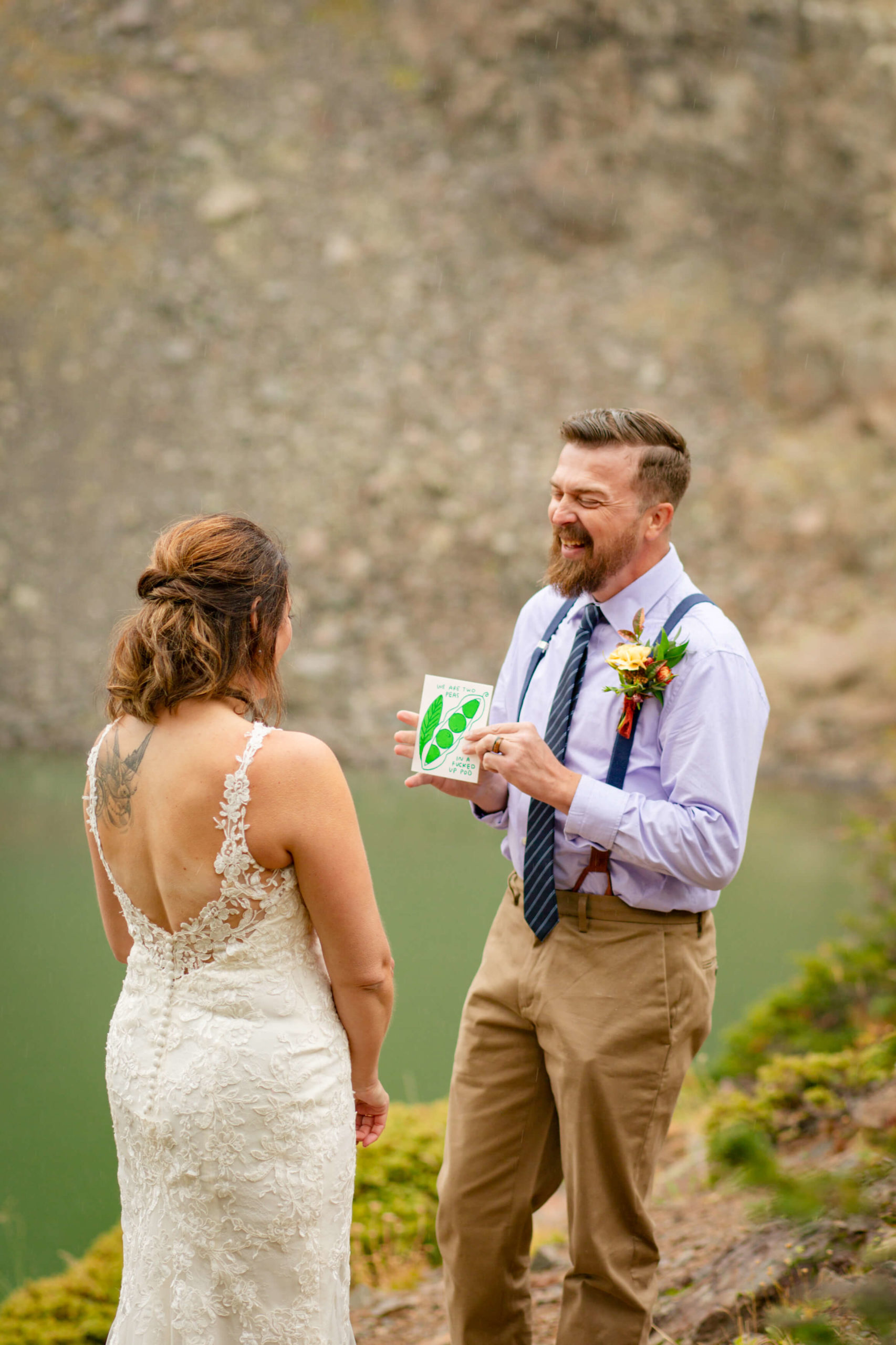 groom laughing while holding a card