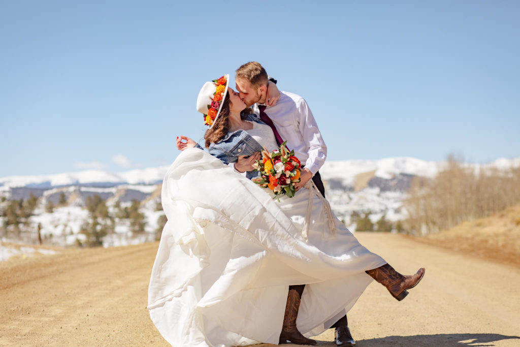 couple kissing while bride perfects the best dress flip