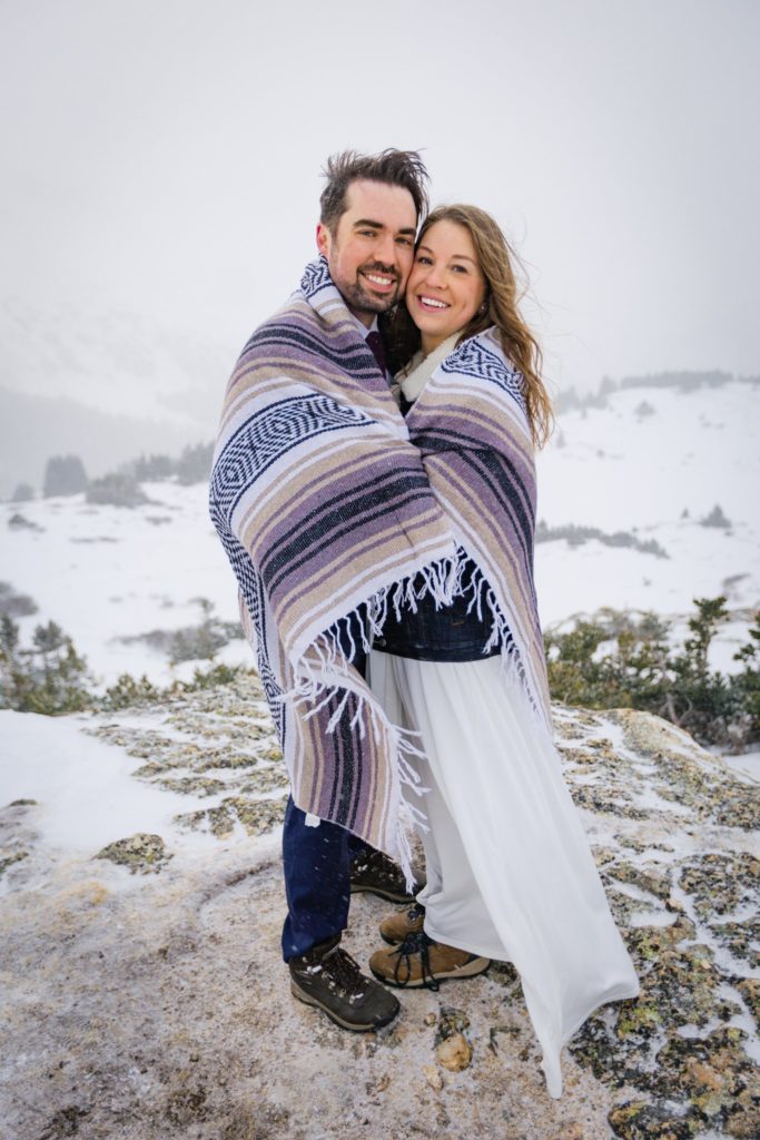 Alexandra and Nate smiling while wrapped up in a blanket.