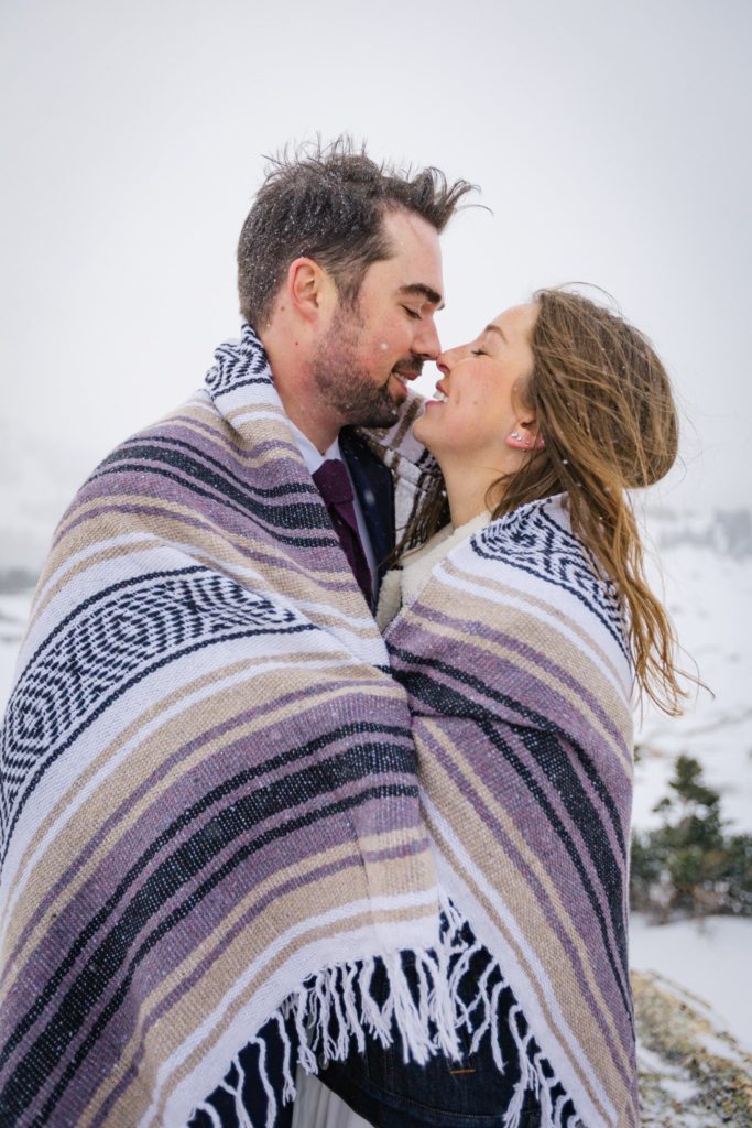 Couple sharing an intimate moment while wrapped up in a blanket.