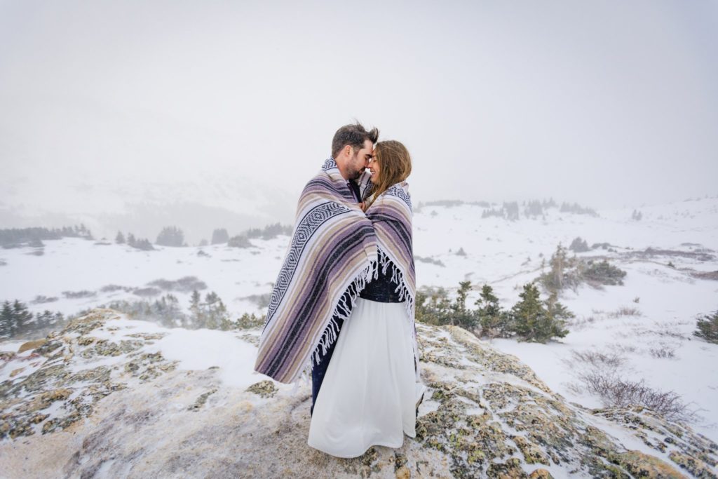The couple wrapped in a blanket holding each other.