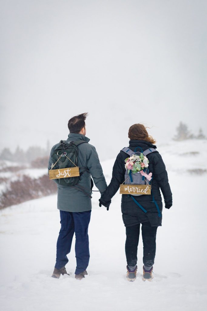 Couple bundled up in their cold gear bracing for their winter elopement.