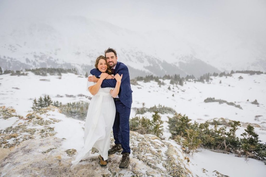 Bride and groom holding each other in Colorado's winter wonderland. 