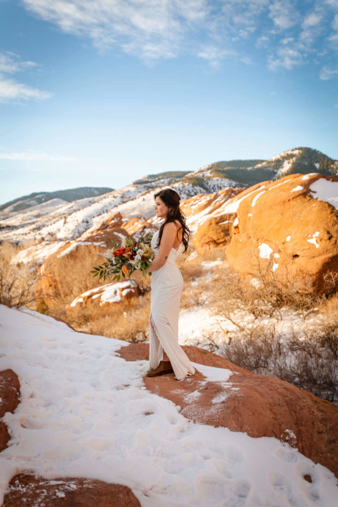 Bride overlooking the Red Rocks covered in snow at Morrison, Colorado.