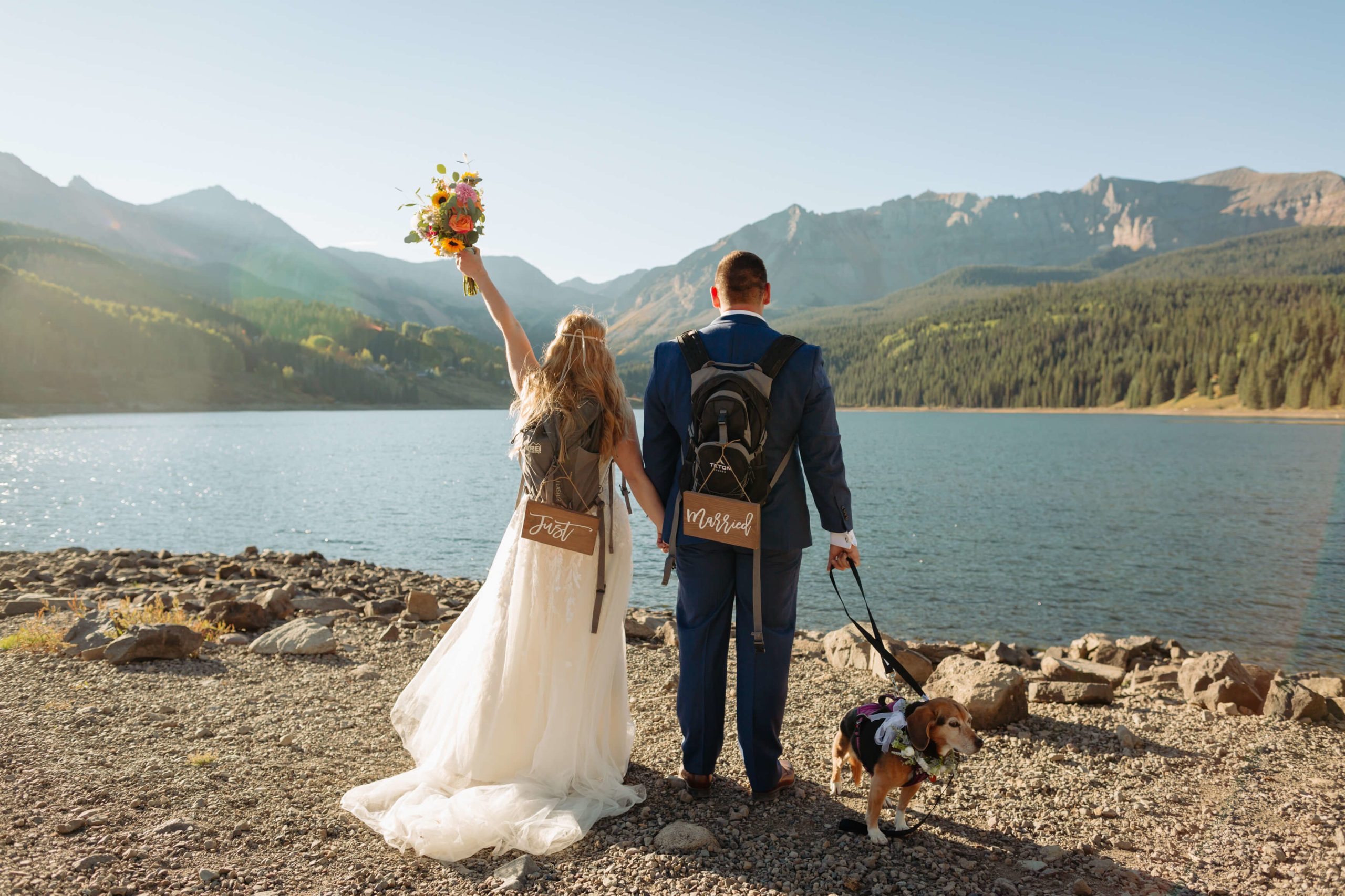 bride, groom, and flower dog pose, looking towards the lake and Telluride mountain range
