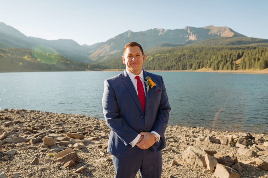 portrait of the groom posing in front of the lake