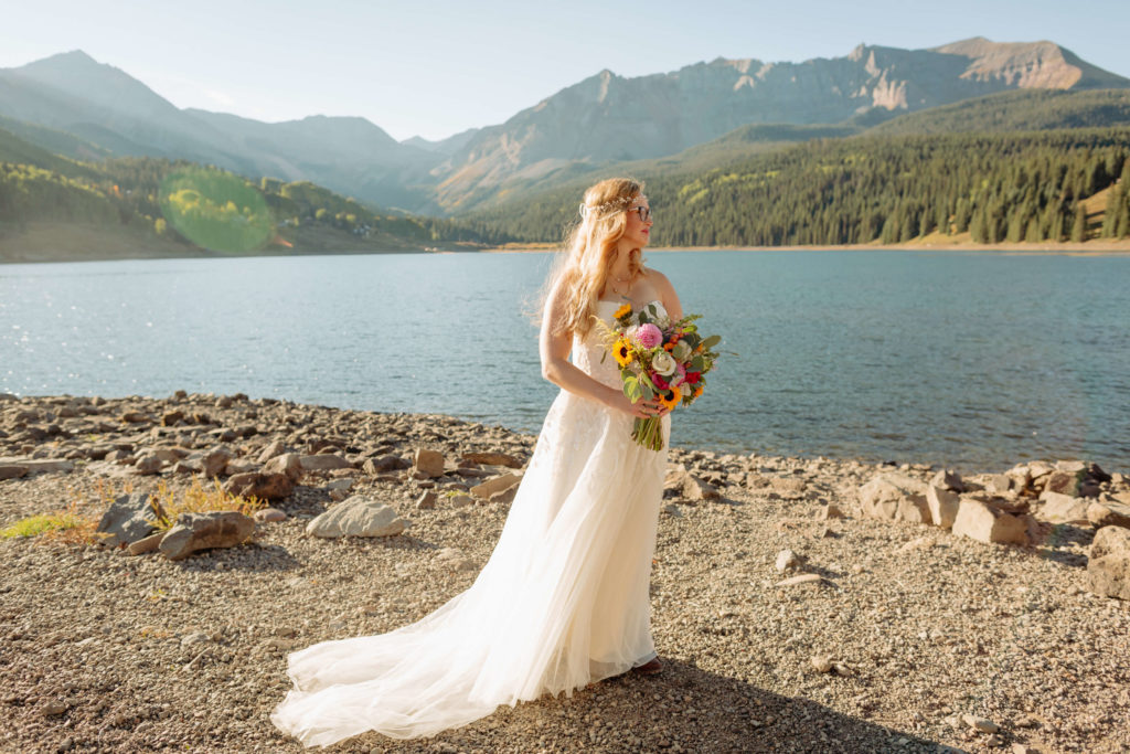Bride posing in front of lake and Telluride mountains