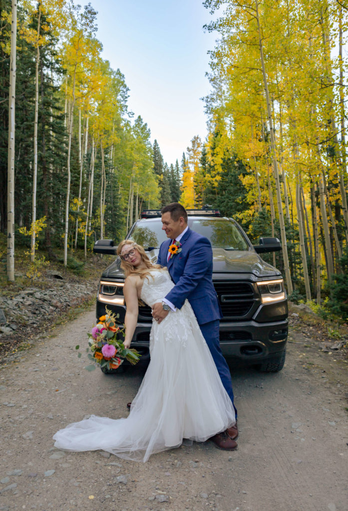 groom holding bride in front of dodge ram pickup