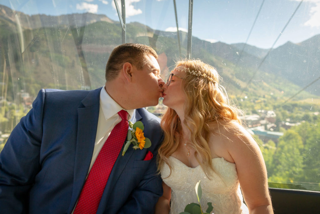 the bride and groom kissing on the gondola