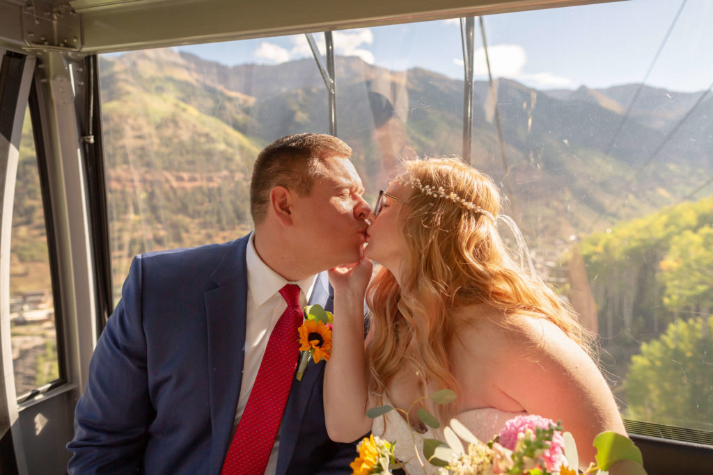 the bride holding her groom's cheek while kissing him on the gondola