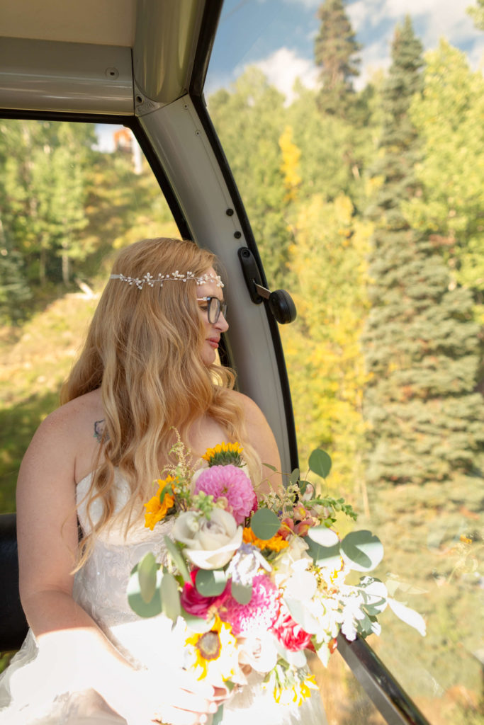 portrait of the bride holding her bouquet while looking out the gondola window