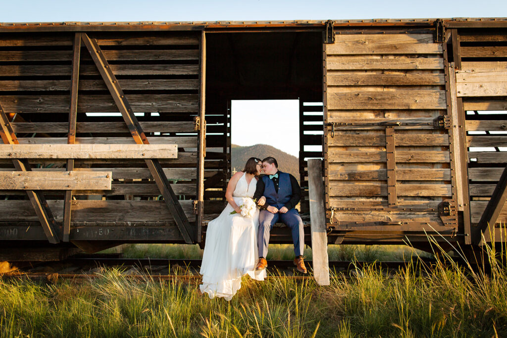 Bride and groom sit on an abandoned train during their elopement.