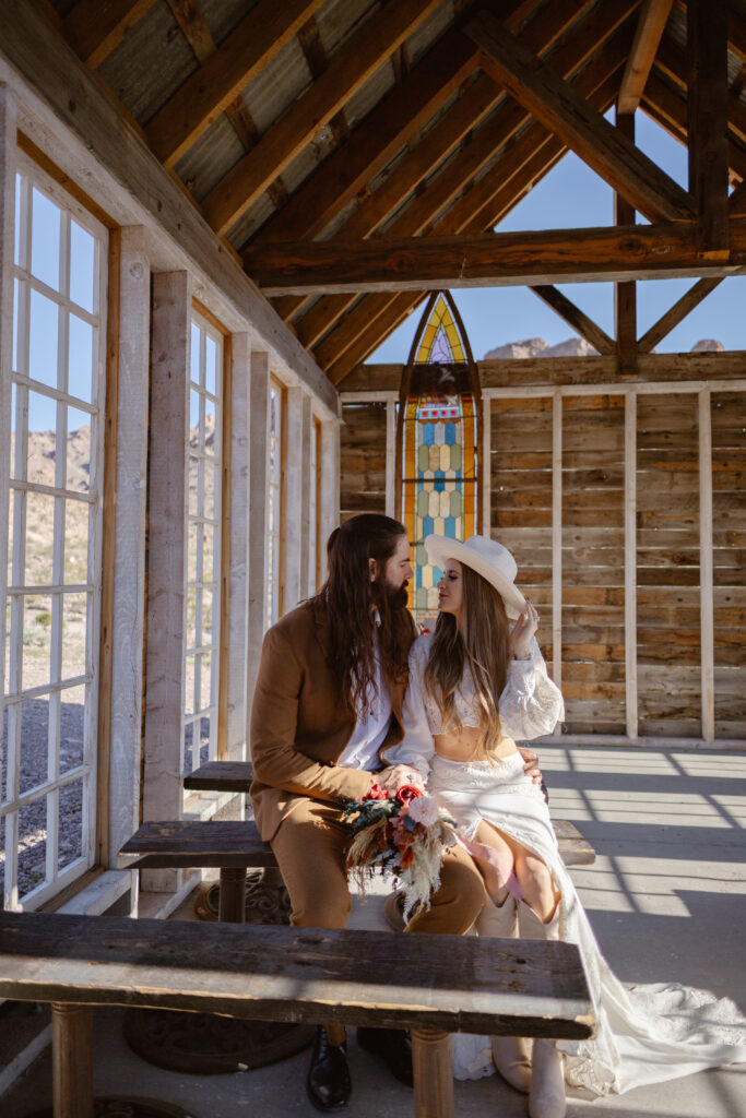 Bride and groom look at each other while sitting in the little wooden church at Nelson's Ghost Town.