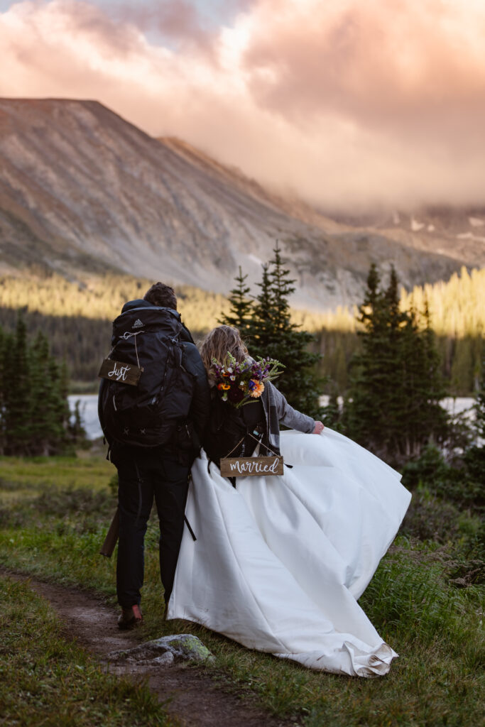 Bride and groom admire the sunrise during their adventure session at long lake