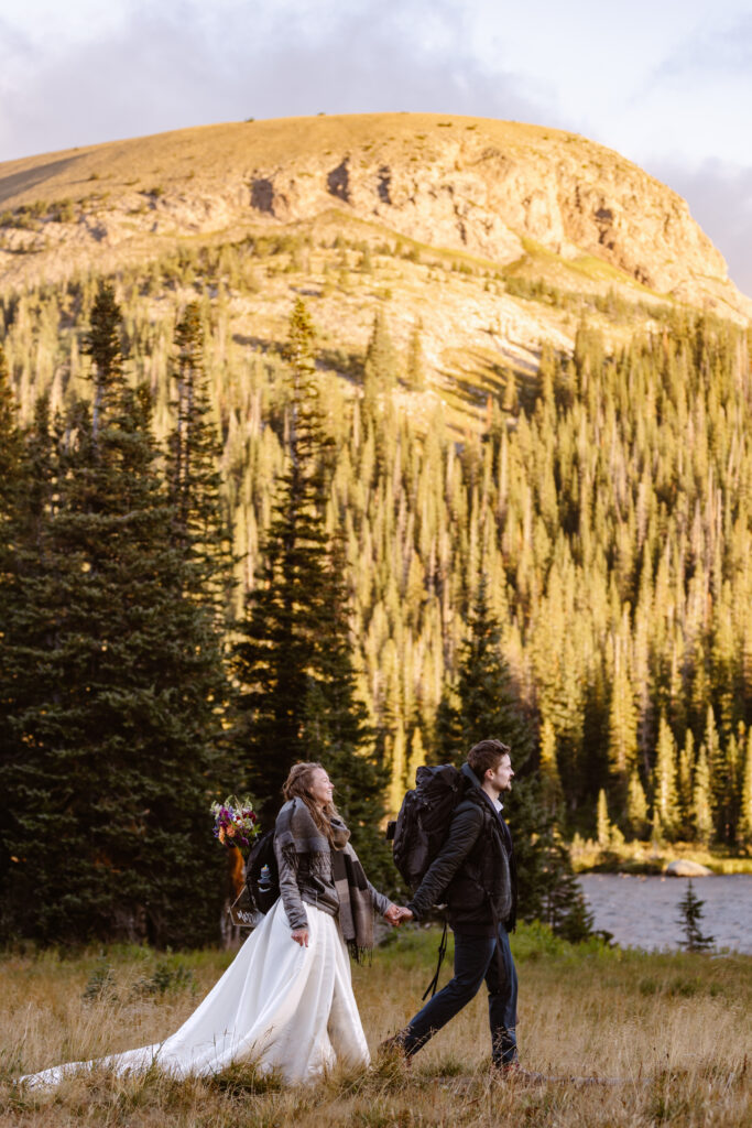 Bride and groom walk along the path during sunrise at long lake for a post wedding adventure session