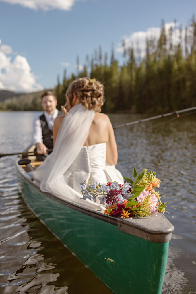 Bride and groom get settled in their canoe to take out after their ceremony